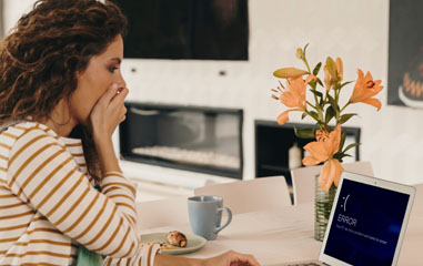 chica sorprendida con pantalla de error en el ordenador